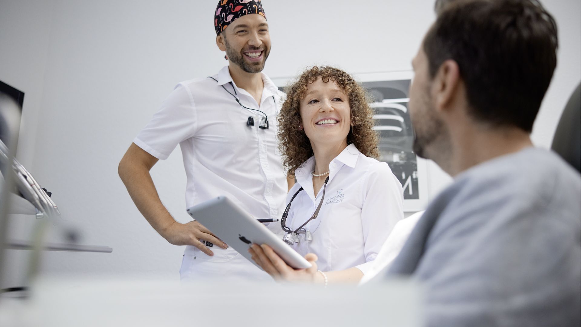 Portraitfotos Dr. Lara und Dr. MArvin Hofmann am Behandlungsstuhl mit Patienten